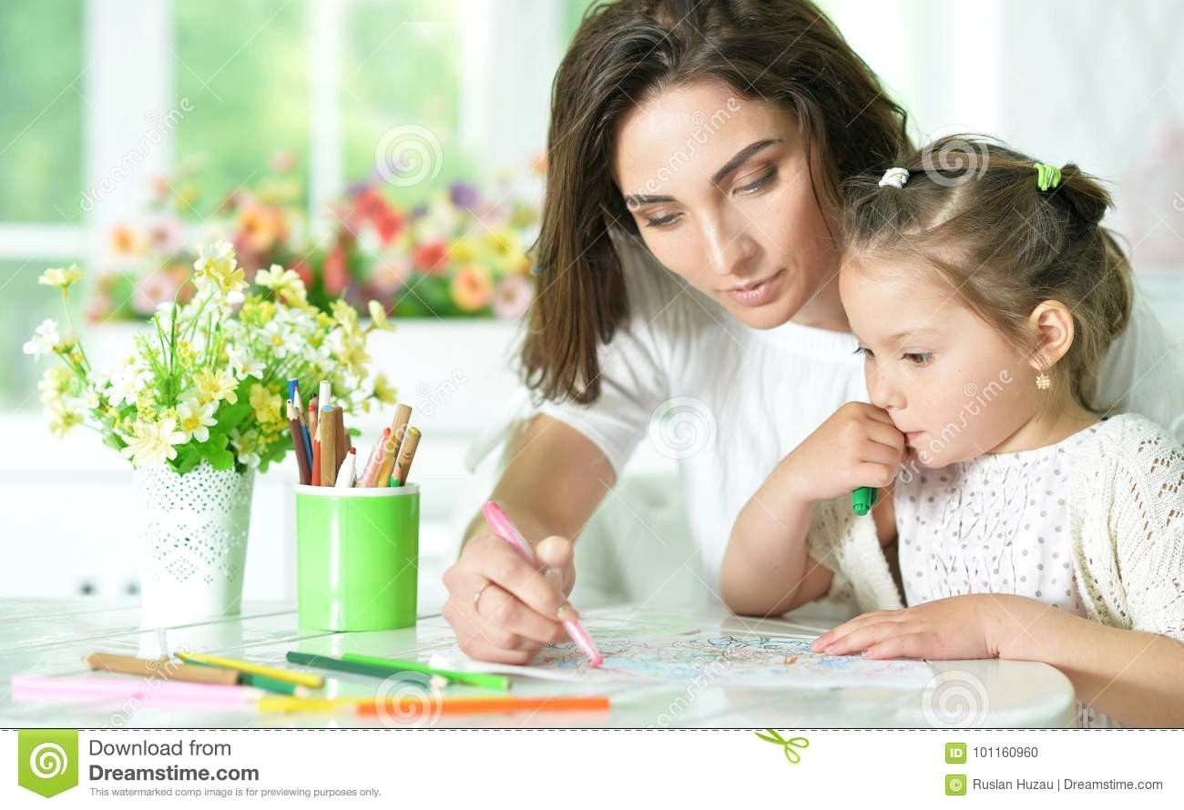 mother and little daughter drawing with pencils