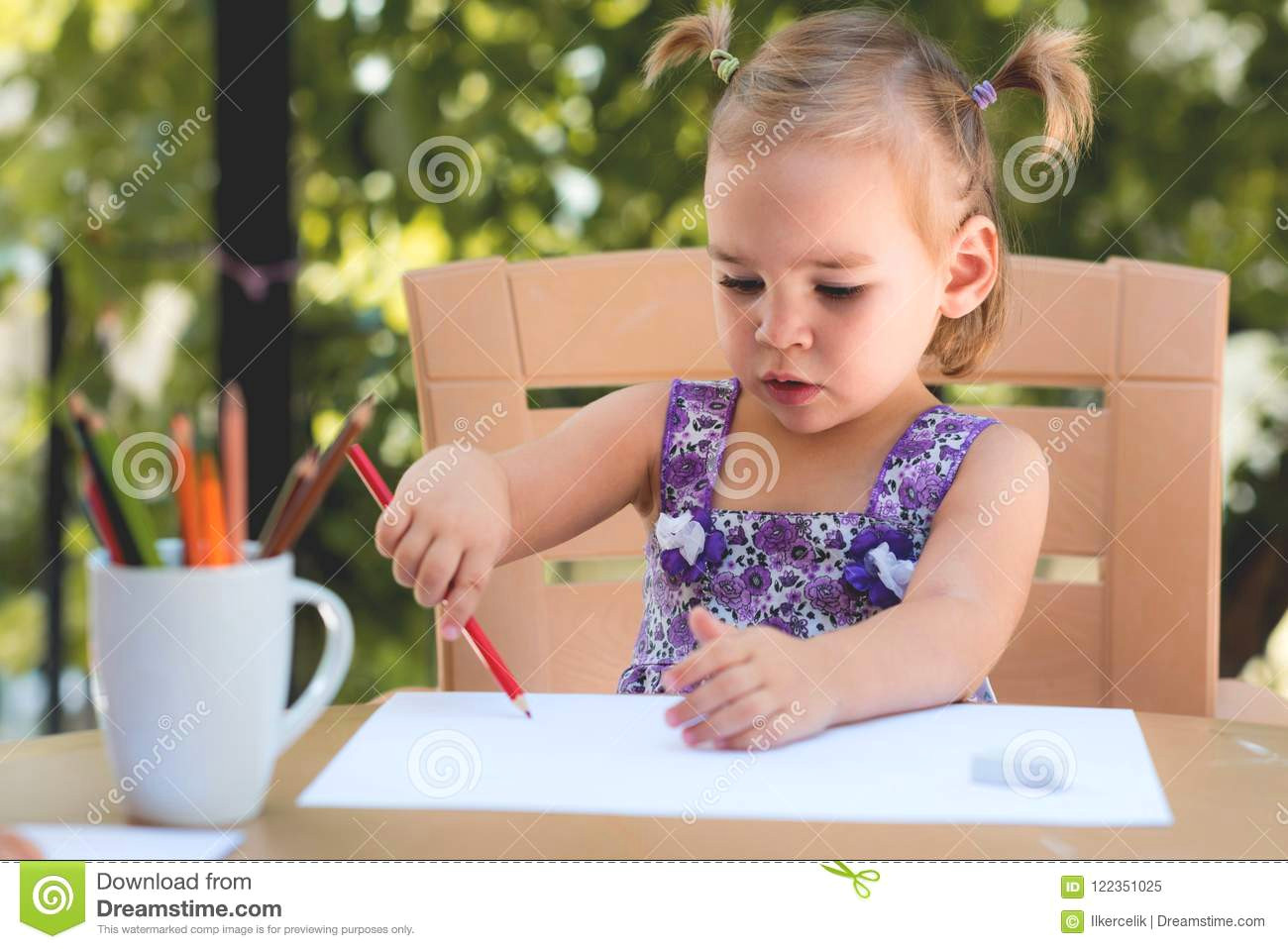 happy smiling baby girl drawing pictures outdoors