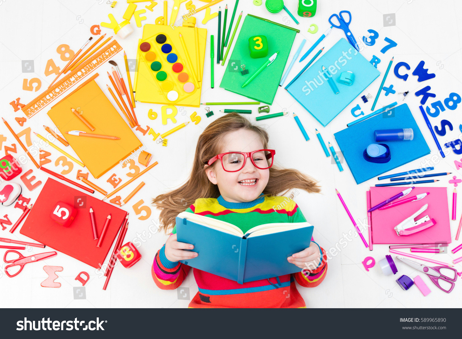 little girl with school supplies books drawing and painting tools and materials happy