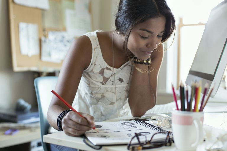 young female artist drawing jewelry design in sketch book