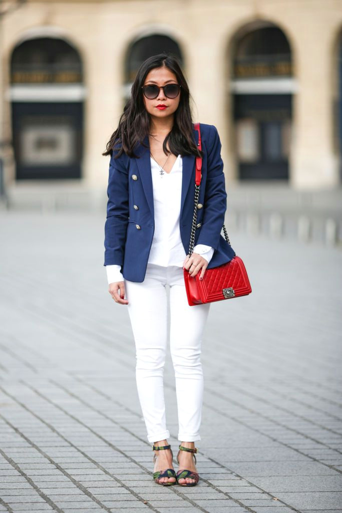 street style woman in denim jacket and white jeans and red purse