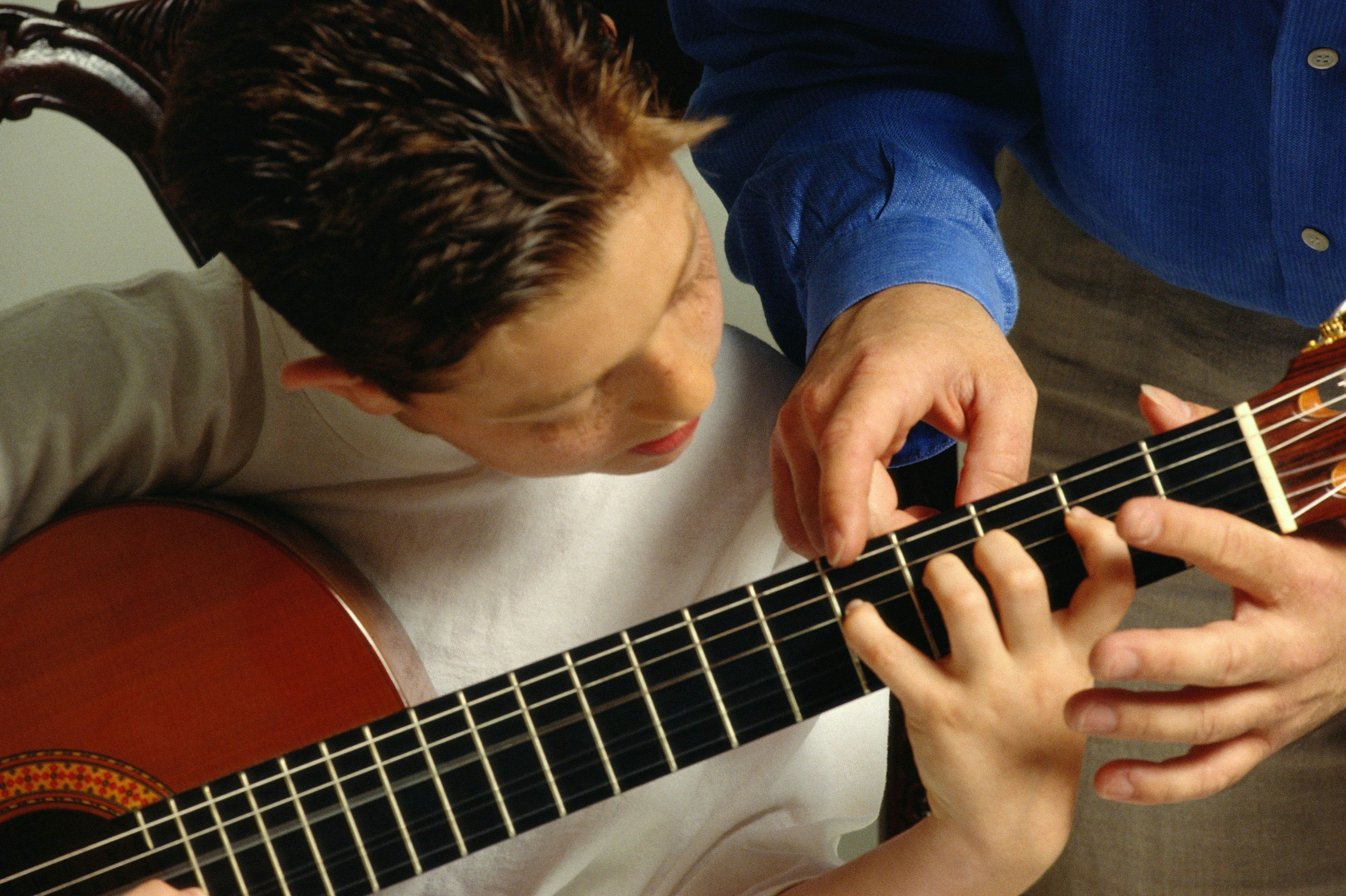 teaching young boy guitar 10140747 58e5285b3df78c5162b342ba 5b7c2b5146e0fb008213b3bc jpg